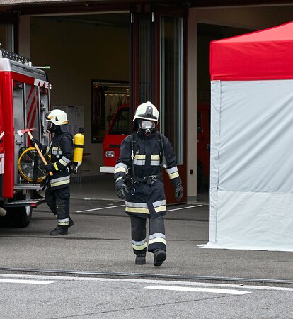 Feuerwehrmann mit Atemschutzgerät geht zwischen Auto und dem Kit Rescue vorbei.