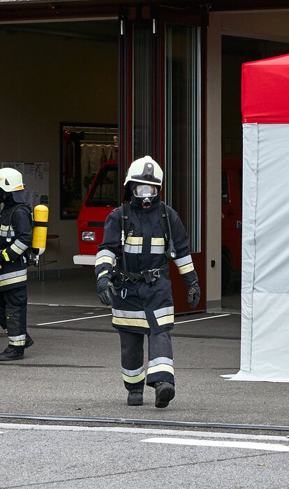 Feuerwehrmann mit Atemschutzgerät geht zwischen Auto und dem Kit Rescue vorbei.