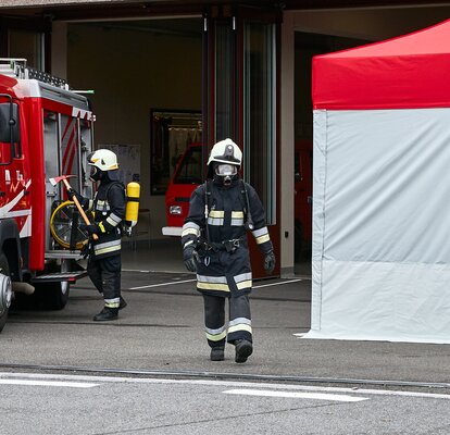 Il vigile del fuoco con respiratore passa tra la macchina e il kit Rescue. 