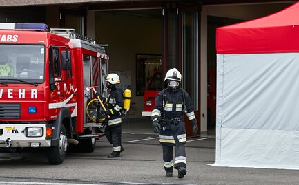Il vigile del fuoco con respiratore passa tra la macchina e il kit Rescue. 
