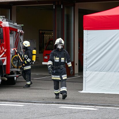 Il vigile del fuoco con respiratore passa tra la macchina e il kit Rescue. 