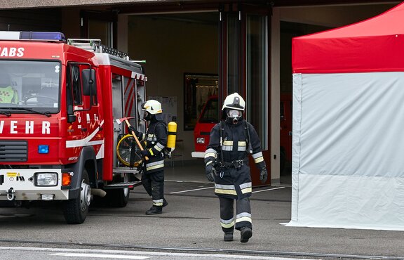 Il vigile del fuoco con respiratore passa tra la macchina e il kit Rescue. 