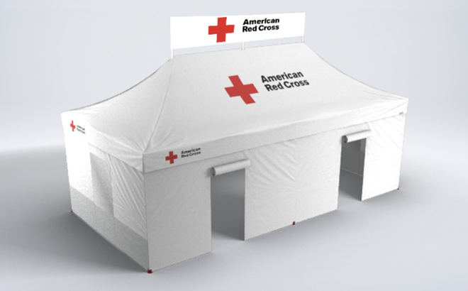 Ein weißes Sanitätszelt ist mit dem Logo des roten Kreuzes der Vereinigten Staaten bedruckt. Es hat die Dimensionen 4,5x3m und einen Banner auf der Dachspitze. 