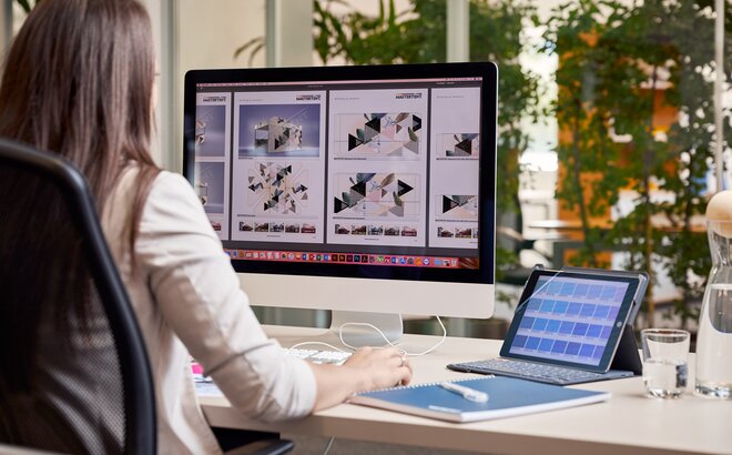 Grafikmitarbeiterin sitzt am Computer und erstellt einen Faltpavillon für einen Kunden.