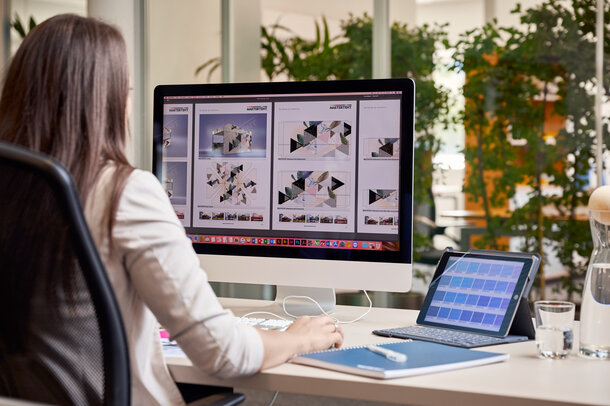 A graphic employee is sitting in front of the computer. She is designing a gazebo for a customer. 