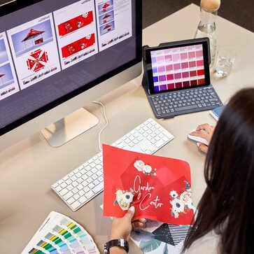 Un designer del team grafico progetta un gazebo personalizzato Mastertent rosso con grafiche a fiori