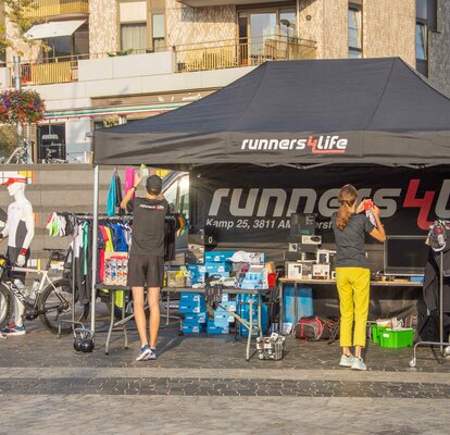 Gazebo promozionale nero 4,5x3m personalizzato con logo, parete laterale e beachflag per stand all'aperto Runners4life.