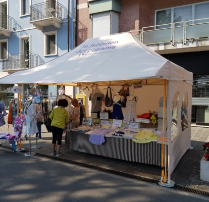 Gazebo pieghevole 4,5x3 m ecru con pareti laterali intere e con finestra e tettoia per la vendita di vestiti de La Fabbrica del Pigiama.