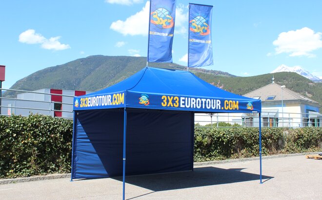 Gazebo pieghevole 4,5x3m personalizzato con logo, parete laterale e bandiere per promozione eventi di basket 3x3 Eurotour.