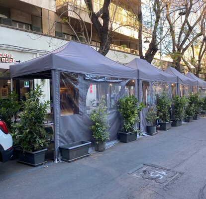 Gazebo pieghevole elegante e moderno grigio 4x2 m con pareti laterali con finestre. Fila di gazebo utilizzati nell'area esterna del locale bar ristorante Sazi e Sani per le vie della città