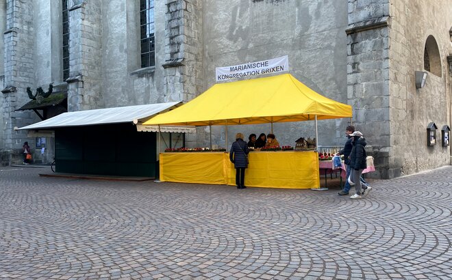 Yellow 6x3 gazebo with awning and half-height side wall with custom banner in a glimpse of Brixen, Italy