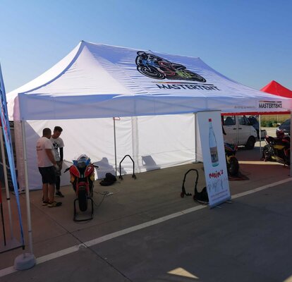 Gazebo pieghevole 8x4 bianco personalizzato con logo Motul, parete laterale e bandiere