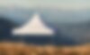 A white pagoda tent is placed in the sunset at the Plose mountain. 