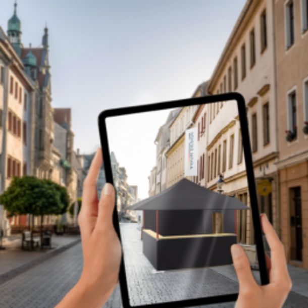 Zwei Hände halten ein Tablet mit dem ein Zelt konfiguriert wird.