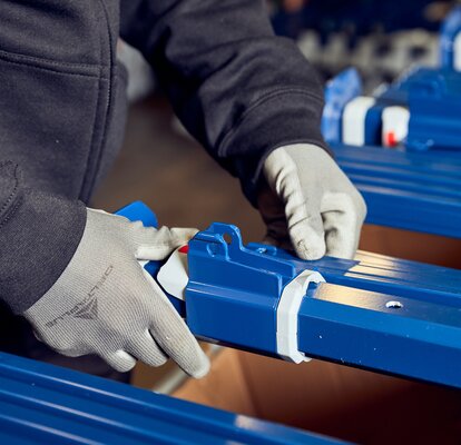 Production employee is assembling the blue tent structure. 