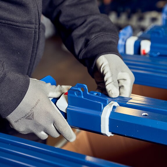 Production employee is assembling the blue tent structure. 