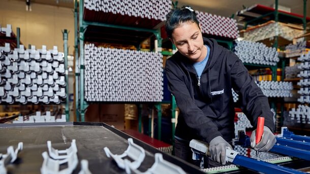 A production employee of MASTERTENT is assembling the blue structure. 