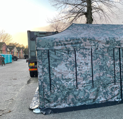Tarnfarbener Faltpavillon mit geschlossener Seitenwand.