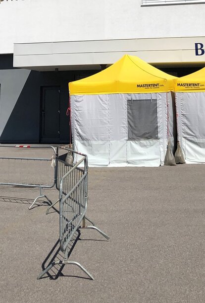 Pre-Triage Tent with a yellow roof in front of the private clinic Brixana.