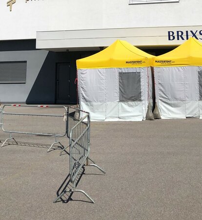 Pre-Triage Tent with a yellow roof in front of the private clinic Brixana.