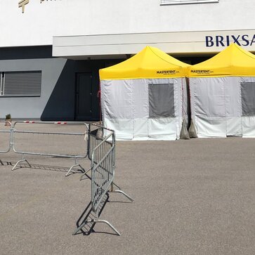 Pre-Triage Tent with a yellow roof in front of the private clinic Brixana.