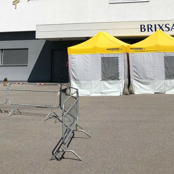 Pre-Triage Tent with a yellow roof in front of the private clinic Brixana.