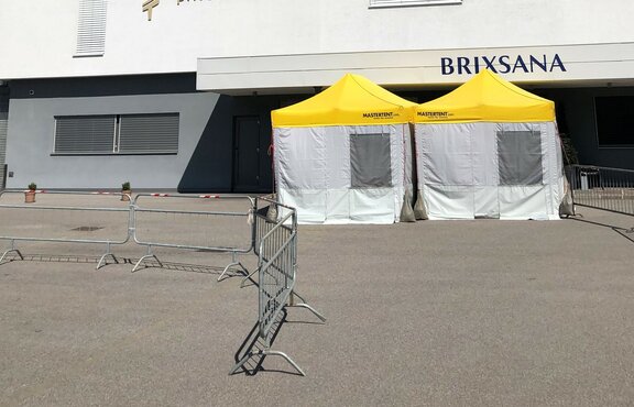Pre-Triage Tent with a yellow roof in front of the private clinic Brixana.