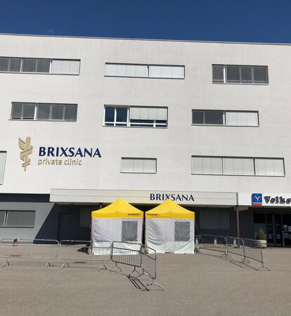 Grau-gelbe Pre-Triage Zelte vor der Privatklinik Brixana.