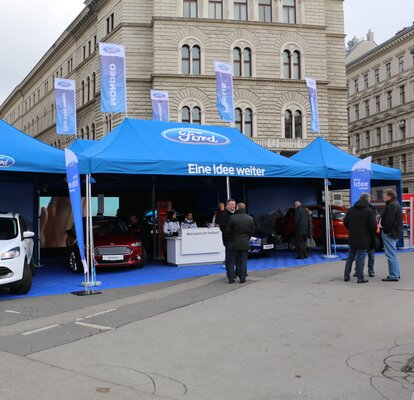 Gazebo promozionale blu chiaro 8x4 m Ford stampato con logo, scritte e bandiere e gazebo promozionale blu chiaro 3x3 m con parete laterale