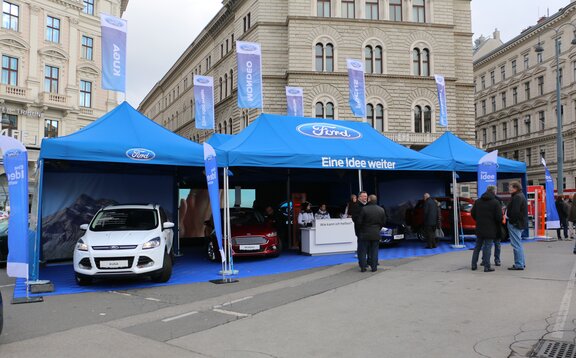 Gazebo promozionale blu chiaro 8x4 m Ford stampato con logo, scritte e bandiere e gazebo promozionale blu chiaro 3x3 m con parete laterale