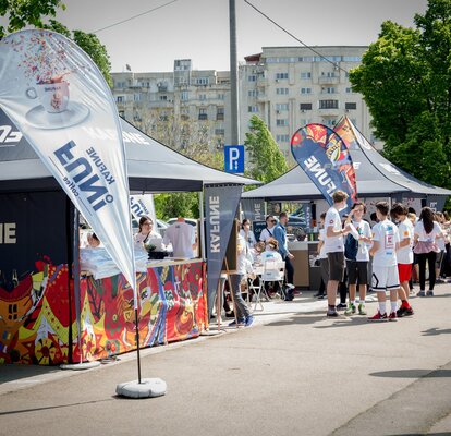 Faltpavillon 3x3 m mit individuellem Aufdruck und Kafune-Logo mit vollen Seitenwänden, halbhohen Seitenwänden mit Theke und individuellen Fahnen. Die Pavillons werden mit 28 kg Gewichten am Boden befestigt.