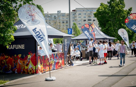 3x3 m gazebo with customised print and Kafune logo with full side walls, half-height side walls with counter and customised flags. Gazebos fixed to the ground with 28kg weights.