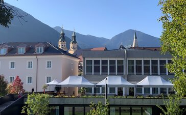 Überdachung der Terrasse vor der Cusanus Akademie in Brixen. Auf der Terrasse stehen weiße Faltzelte der Größe 6x4 m.