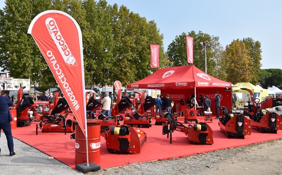 La gazebo pieghevole rosso di Ceccato si trova in mezzo alle macchine rosse. Sotto c'è un tappeto rosso. Il gazebo per le fiera ha 2 bandiere sul tetto. Un'altra bandiera pubblicitaria è davanti.