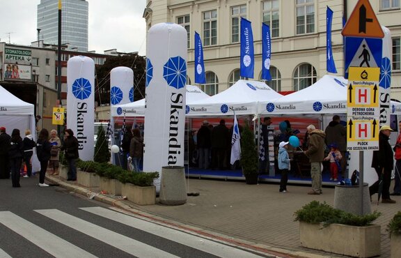 Skandia's three white promotion tents stand on the square. All around them, people are gathering information. Blue flags are on the roofs of the promotion tents.