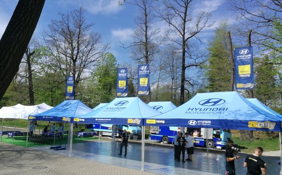 I gazebo paddock Hyundai si trovano presso il circuito di gara. Sono tutti completamente personalizzati e stampati. Ci sono bandiere personalizzate sui tetti.