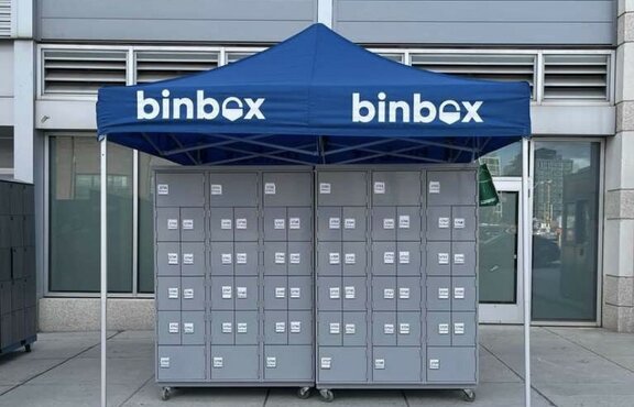 The blue gazebo is in front of the entrance. Underneath are grey boxes and on the roof is Binbox.