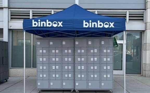 The blue gazebo is in front of the entrance. Underneath are grey boxes and on the roof is Binbox.