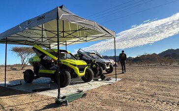 schwarz-weiße Rennzelte bei der Dacar-Rallye 2022 mit zwei Arcane-Autos in der Wüste nahe den Bergen
