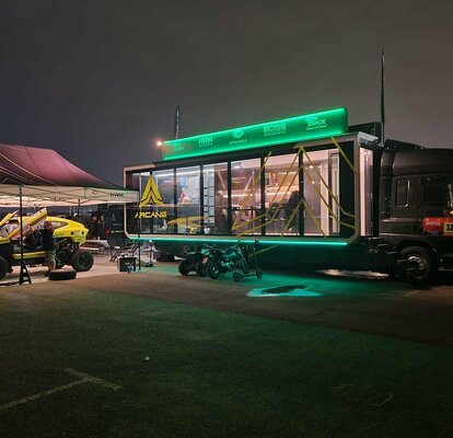 two race gazebos at night with lighting at the Dakar rally 2022 with Arcane race car