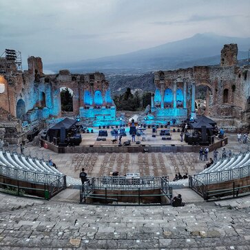 Im Antiken Theater in Taormina stehen rechts und links auf der Bühne jeweils zwei schwarze 3x3 m Faltpavillons. Darunter befinden sich technische Geräte für das anstehende Konzert.