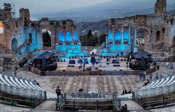 In the Ancient Theatre in Taormina there are two black 3x3 m folding gazebos on the right and left of the stage. Underneath are technical devices for the upcoming concert.