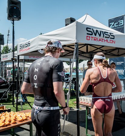 The picture shows two personalised 3x3 folding gazebos. Under them are refreshment drinks for the athletes.