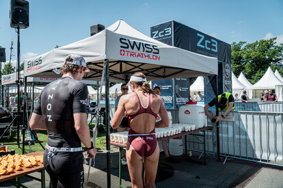 L'immagine mostra due gazebo pieghevoli 3x3 personalizzati. Sotto di essi si trovano bevande per gli atleti.