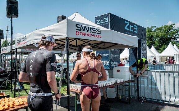 The picture shows two personalised 3x3 folding gazebos. Under them are refreshment drinks for the athletes.