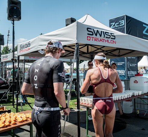 The picture shows two personalised 3x3 folding gazebos. Under them are refreshment drinks for the athletes.
