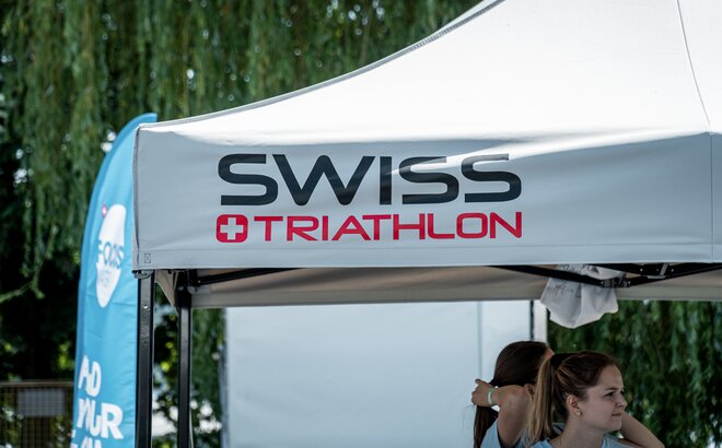 The picture shows the roof of a grey 3x3 m folding gazebo. It was printed with the Swiss Triathlon logo.