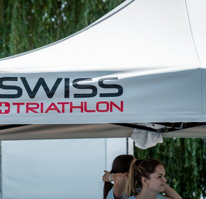 Folding gazebo 3x3 for sport events The picture shows the roof of a grey 3x3 m folding gazebo. It was printed with the Swiss Triathlon logo.