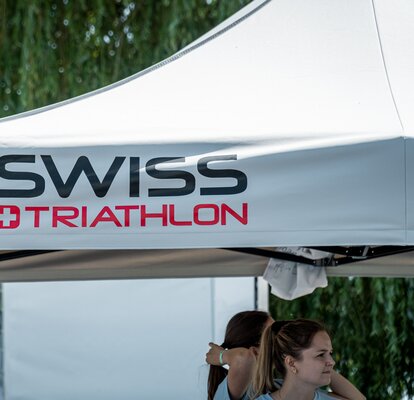 L'immagine mostra il tetto di un gazebo pieghevole grigio di 3x3 metri. È stato stampato con il logo di Swiss Triathlon.