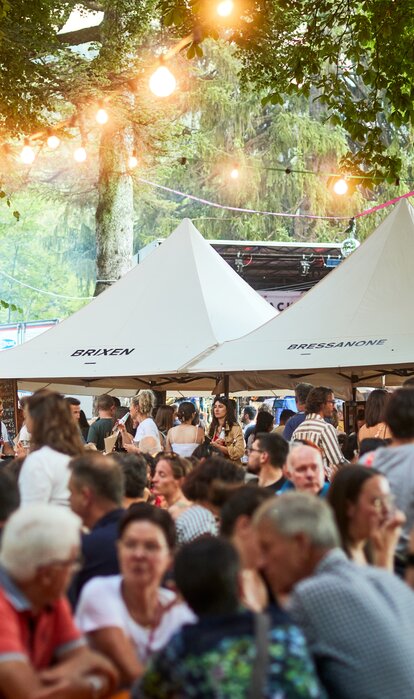 Two white Mastertent canopy tents set up to sell food at a festival.